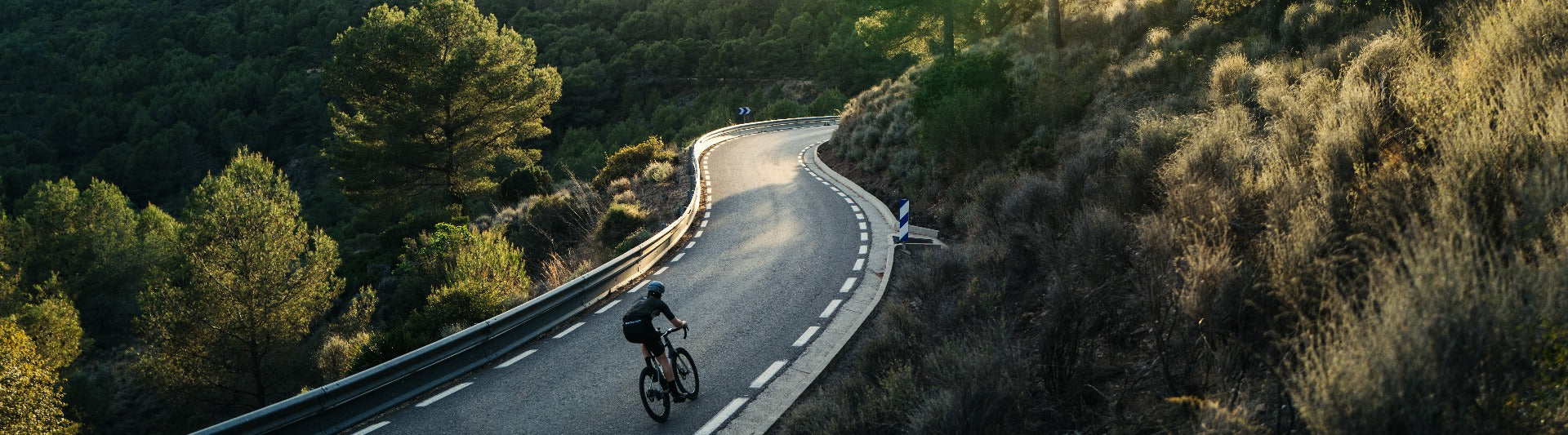 cycliste de dos roulant en vélo sur une route de montagne